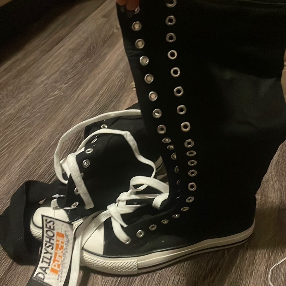 Black, tall converse tennis shoes. New with tags. Size 6.